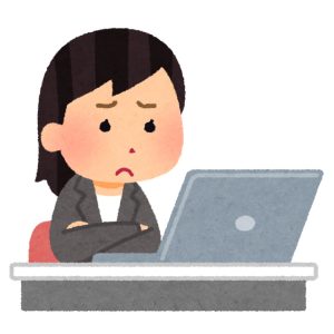 パソコンの前で困っている女性